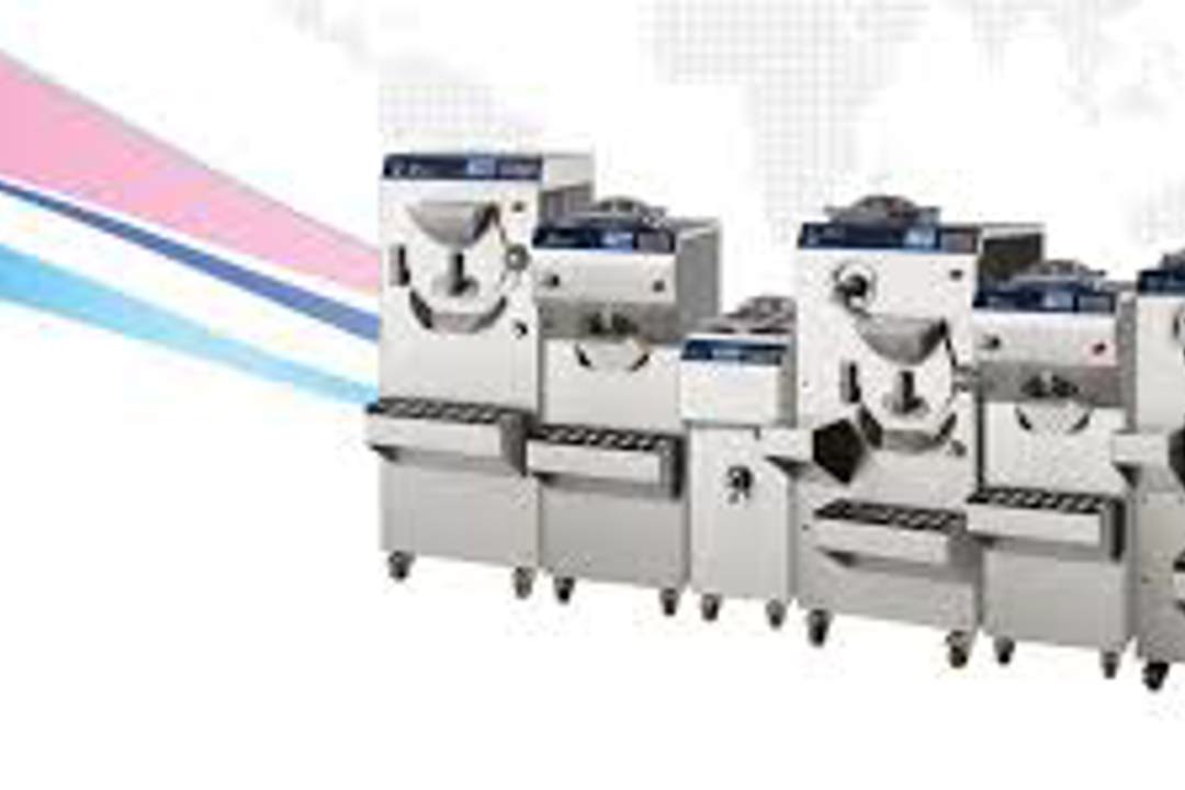 A row of stainless‑steel industrial machines arranged side by side against a beige background with pink and blue graphic lines.