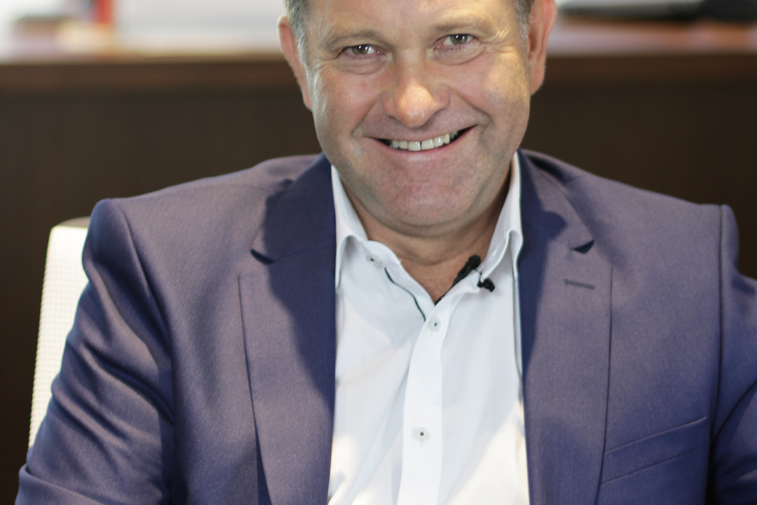 A person wearing a blue business suit is seated in an office setting.